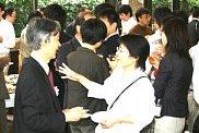 参加者と懇談する岩崎学長(左)